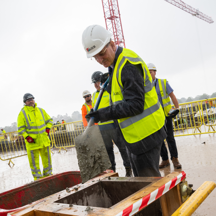 Professor David Rosser adding the final shovel of cement to the ACAD building