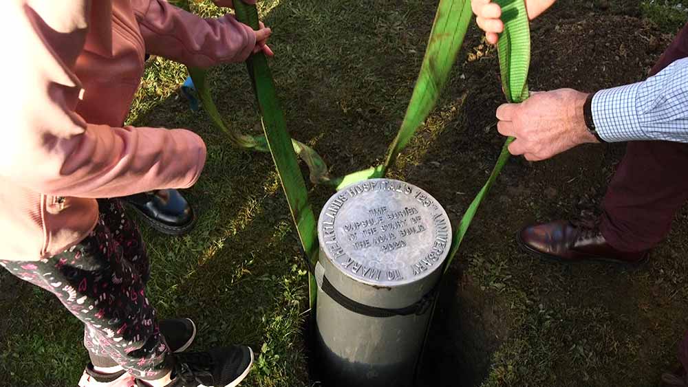 Paediatrics patient Isobel Taylor and Public Governor Keith Fielding bury a time capsule to mark the start of construction on the ACAD Centre.