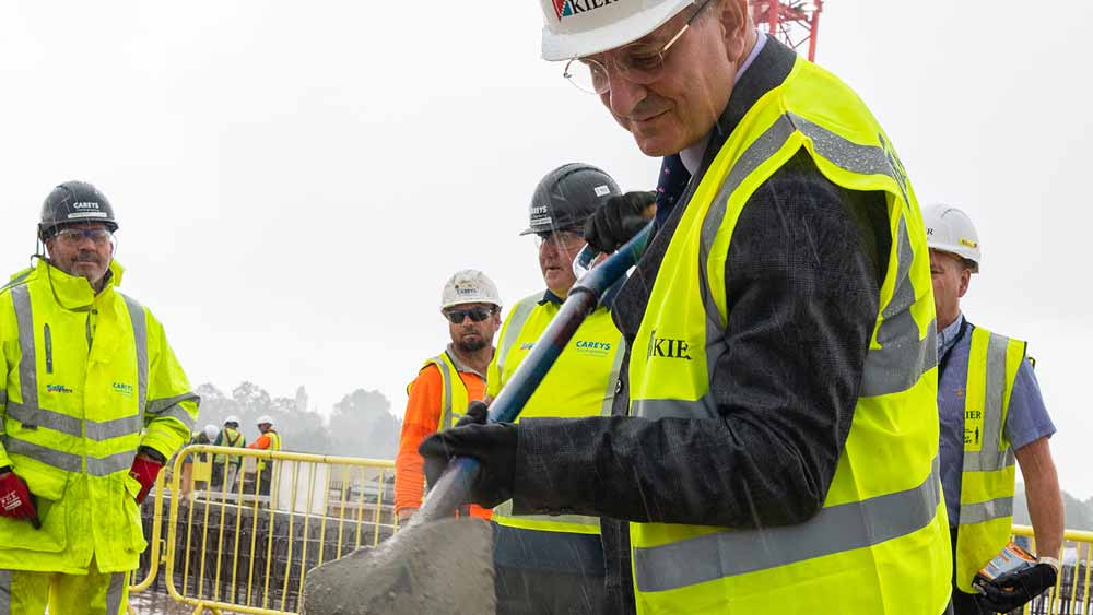 Prof David Rosser lays the final shovel of cement to complete the external structure of the ACAD building